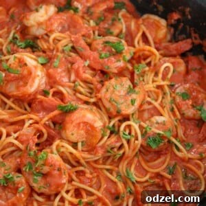 creamy spicy shrimp spaghetti with parsley in a black skillet