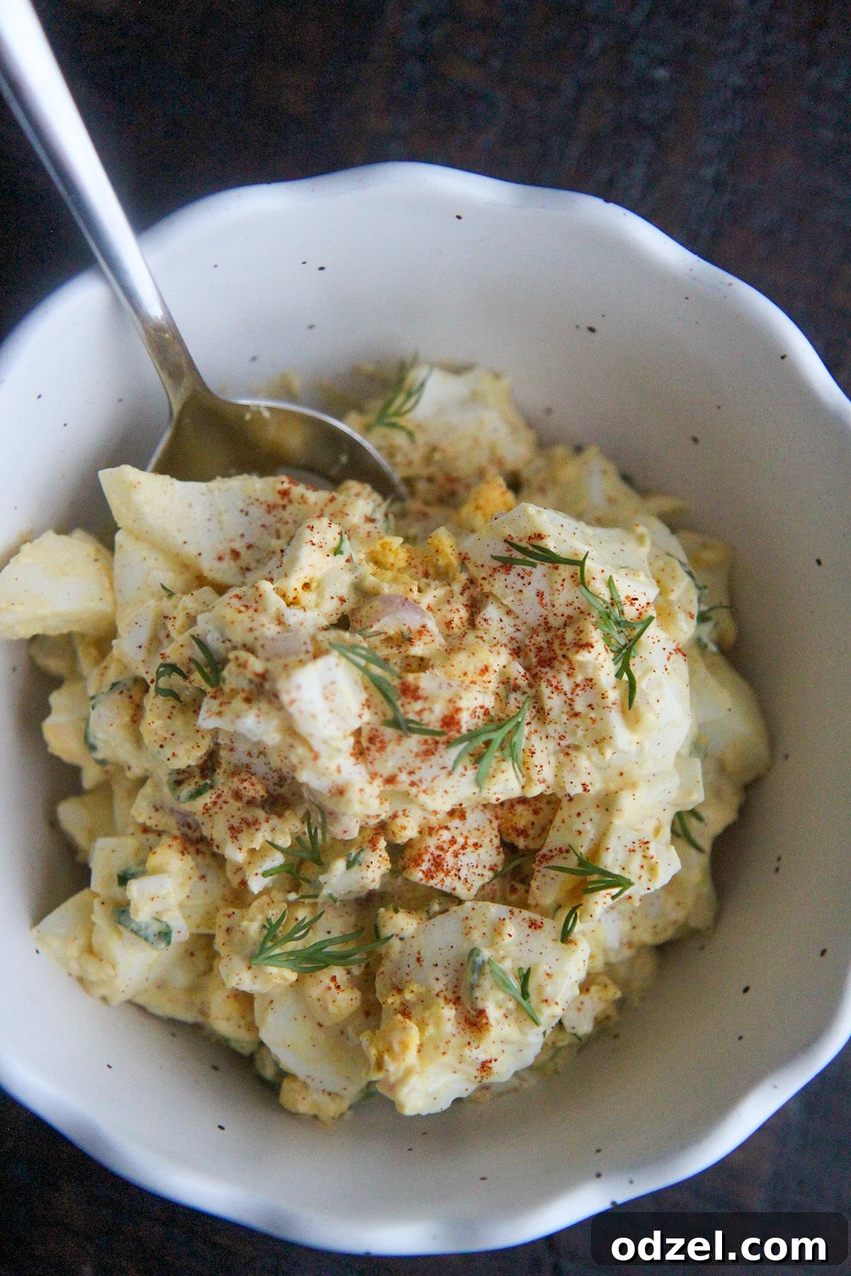 The Perfect Egg Salad 4 egg salad in a bowl with a spoon and paprika on top