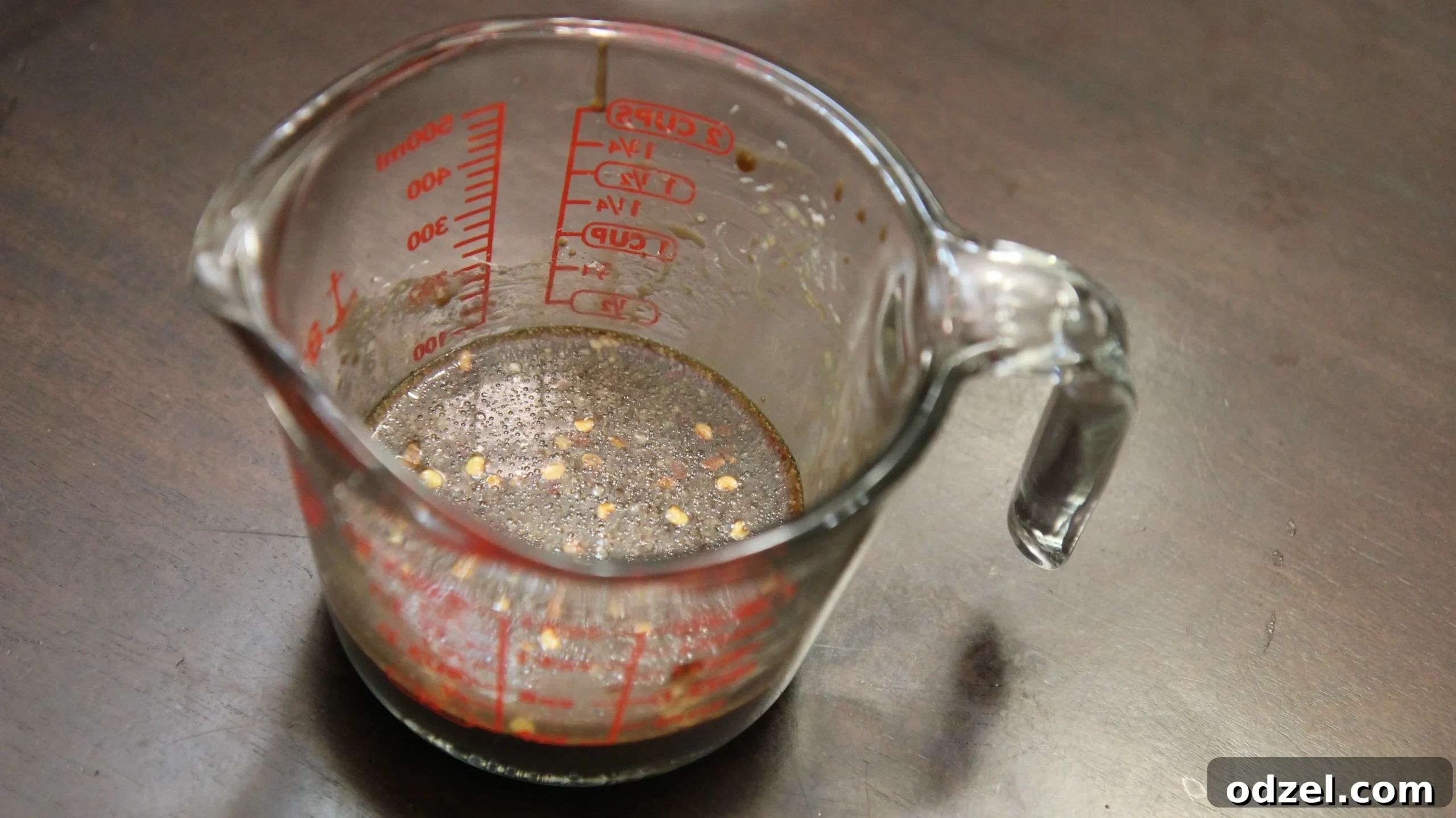 Soy sauce being carefully poured into a clear glass measuring cup, highlighting its role as a fundamental liquid ingredient for the flavorful stir-fry sauce.