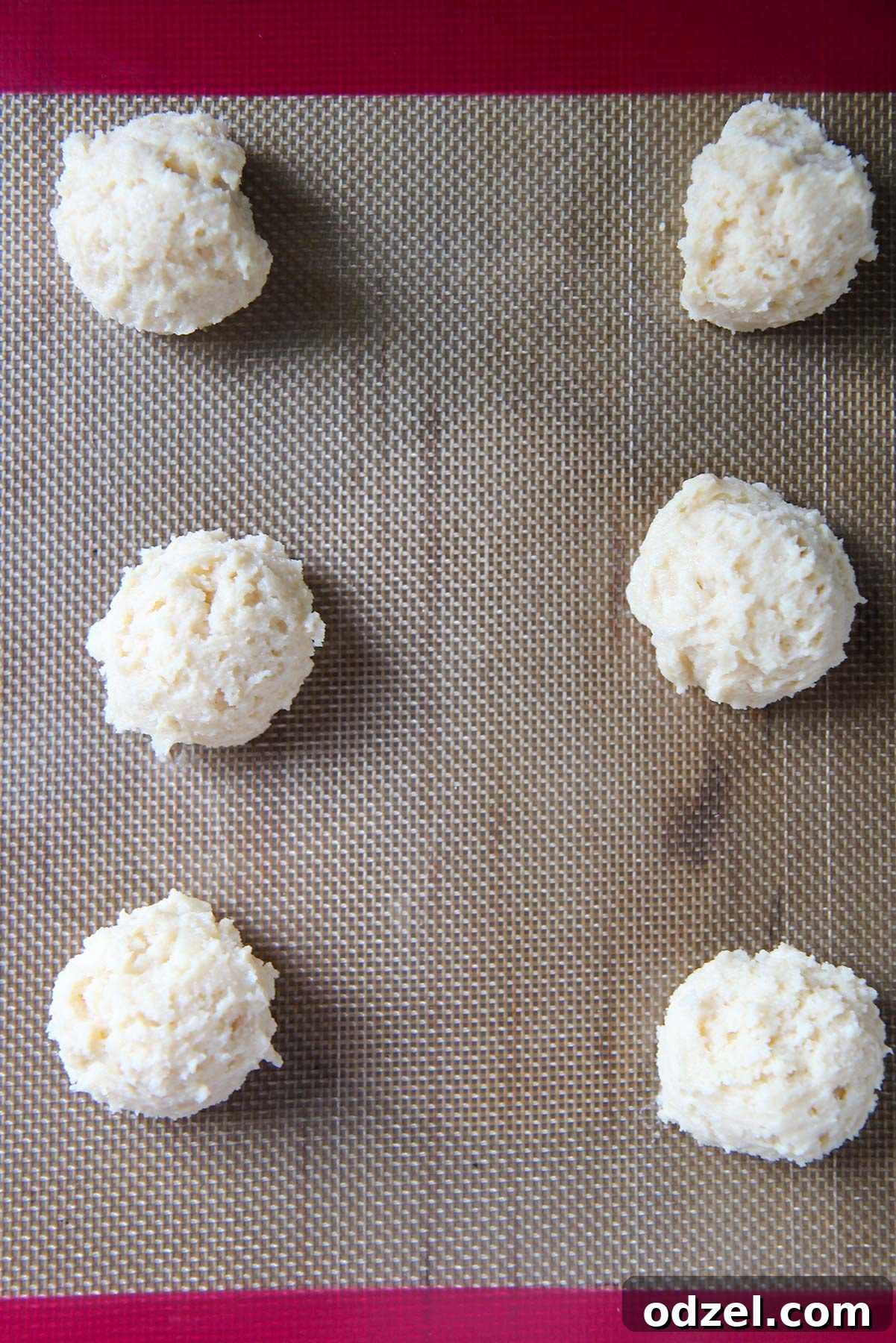 Sunshine-Kissed Lemon Ricotta Bites 3 Six cookie dough balls carefully scooped onto a baking sheet, ready for baking.