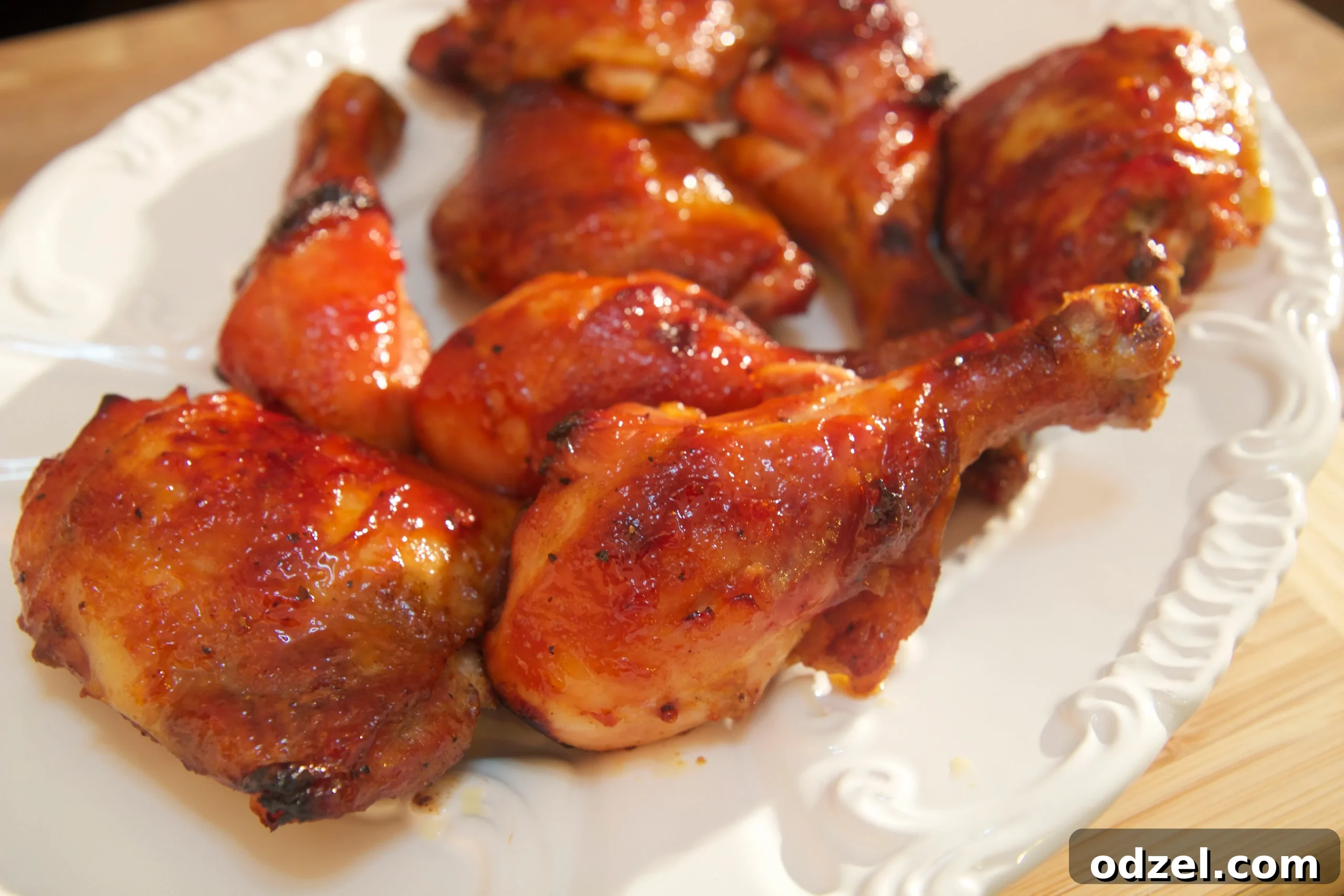 Golden Caramelized Chicken 2 Eight stick chicken legs and thighs on a white platter, glistening with sticky sauce, ready to be served.