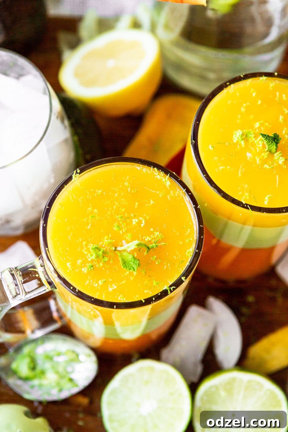Layered Ethiopian Spris 6 Two tall, elegant glasses showcasing a perfectly layered yellow and green juice, an Ethiopian Spris, resting on a rustic wooden serving board, ready to be enjoyed.