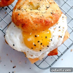 A keto breakfast sandwich with a sunny side up egg, everything bagel, and cheese on a wire rack.