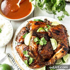 Jamaican jerk chicken on a white plate with cilantro and lime wedges.