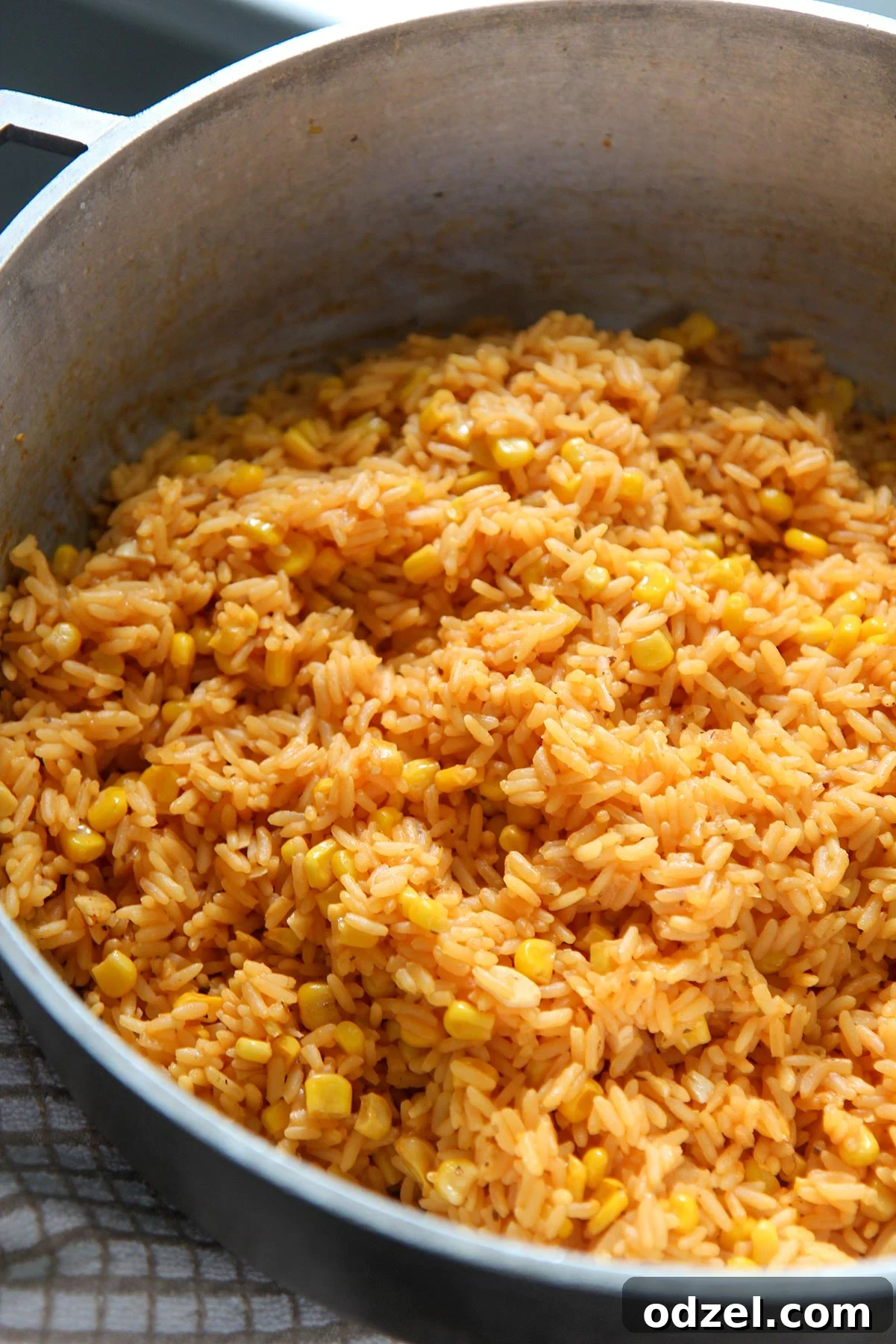 Golden Rice and Sweet Corn Pilaf 2 A large, rustic pot filled to the brim with vibrant yellow rice and kernels of sweet corn, steam gently rising.