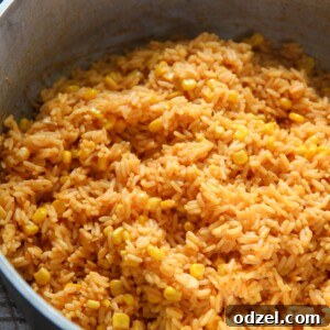 A close-up of vibrant yellow rice with corn, perfect for a recipe card.
