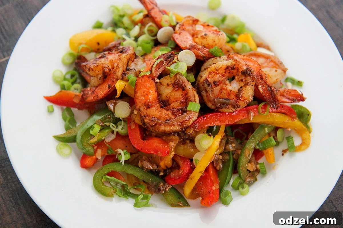 Fiery Jerk Shrimp 3 A serving of perfectly cooked jerk shrimp with vibrant bell peppers and onions, ready to be enjoyed.