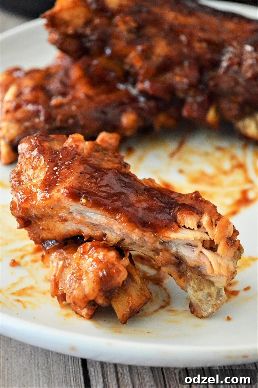 Barbecue ribs on a white plate, beautifully glazed and ready for serving.