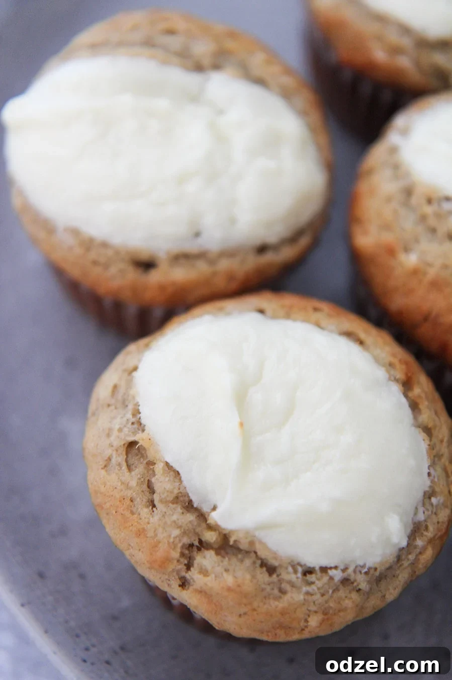 Top view of freshly baked cream cheese banana muffins, highlighting their golden-brown tops and creamy dollops