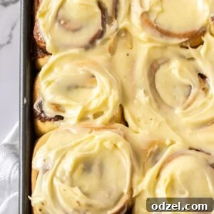 Six jumbo cinnamon rolls with cream cheese frosting up close.