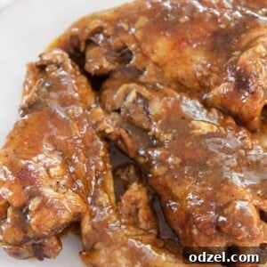 smothered wings on a white plate up close.