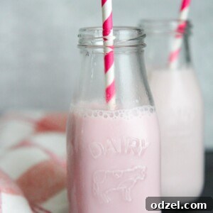two milk jugs filled with strawberry milk and pink and white straws.