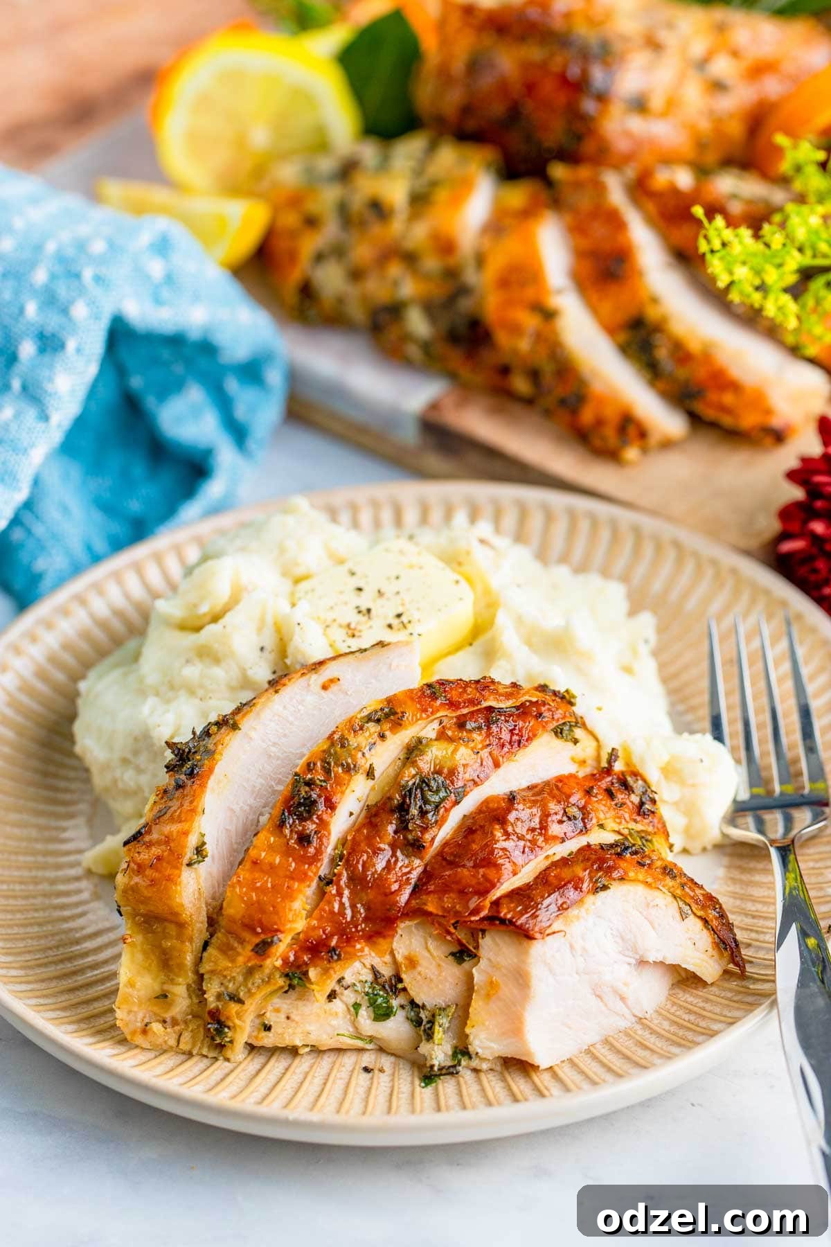 sliced juicy roast turkey breast with mashed potatoes and a fork on a plate. 