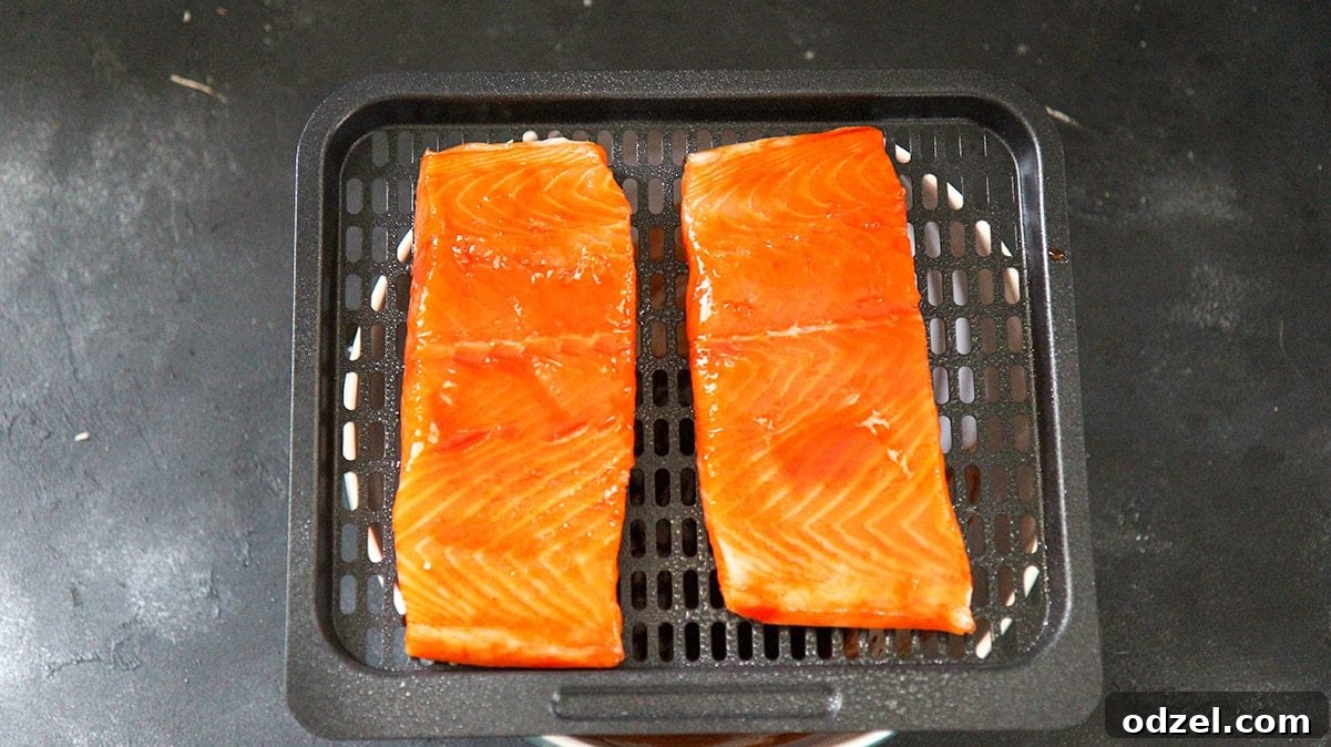 Honey Sriracha Glazed Air Fryer Salmon 3 two raw salmon fillets on the air fryer basket.