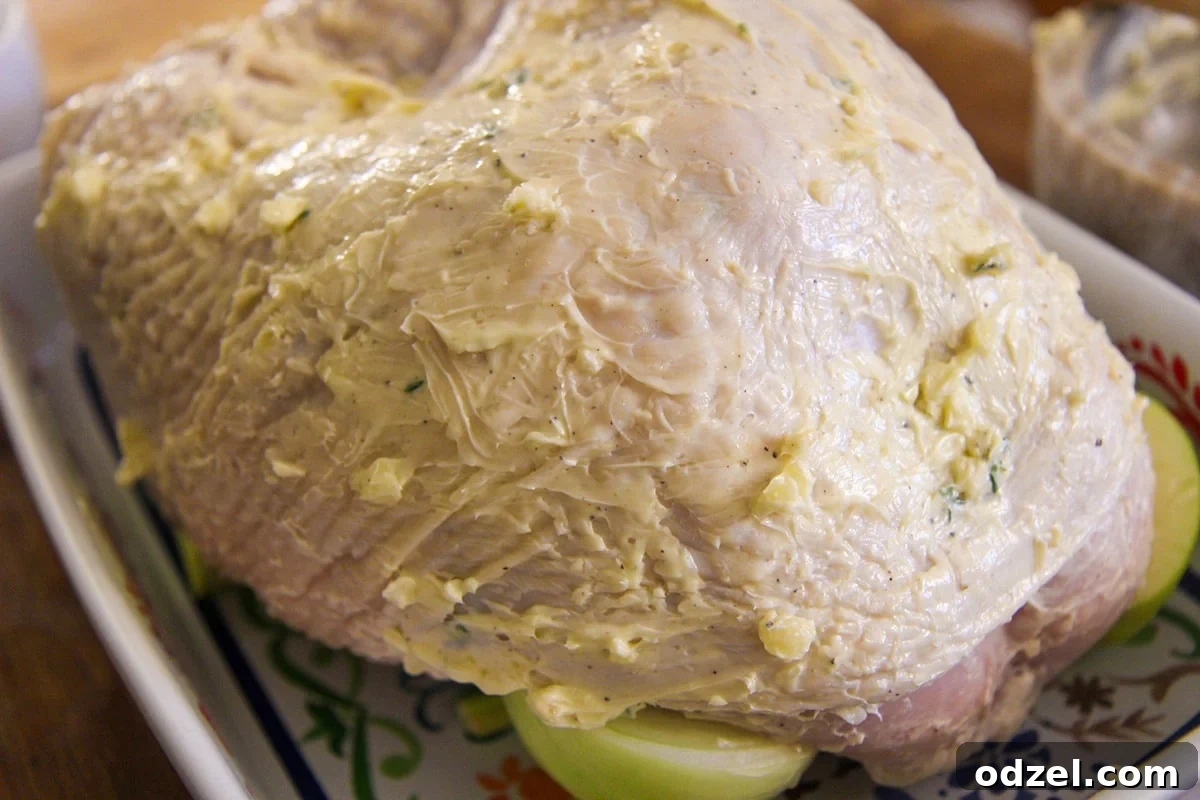 Golden Maple Glazed Turkey Breast 3 Raw turkey breast generously coated with a garlic herb butter mixture, ready for roasting.