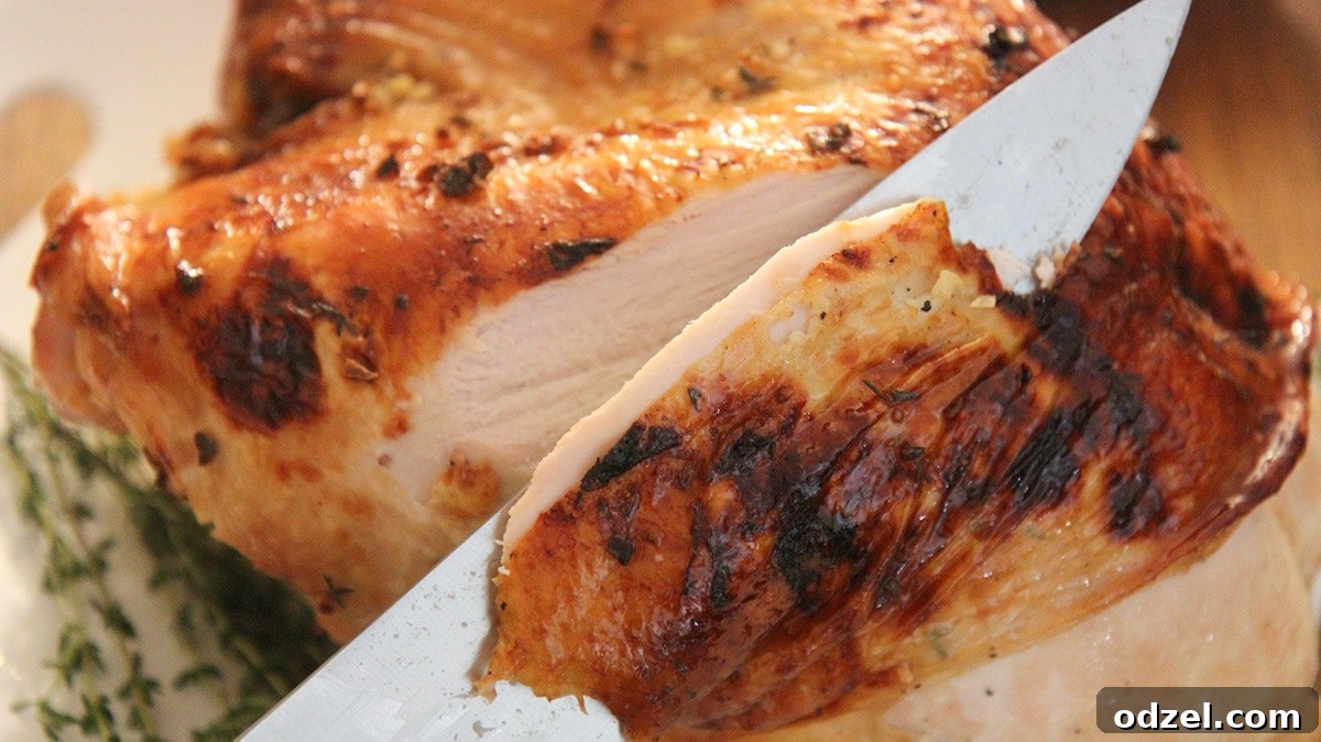 Golden Maple Glazed Turkey Breast 4 A sharp knife slicing into a beautifully roasted and juicy turkey breast, revealing the tender white meat inside.