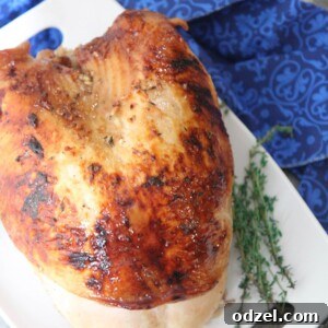 Maple glazed turkey breast on a white platter with fresh thyme on the side.