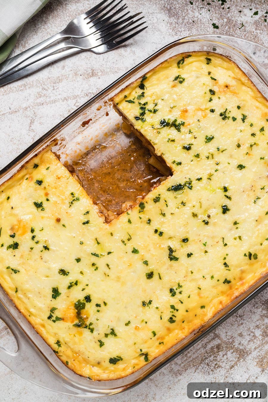 An entire pastitsio casserole dish with a generous slice missing, showcasing its delicious layers.