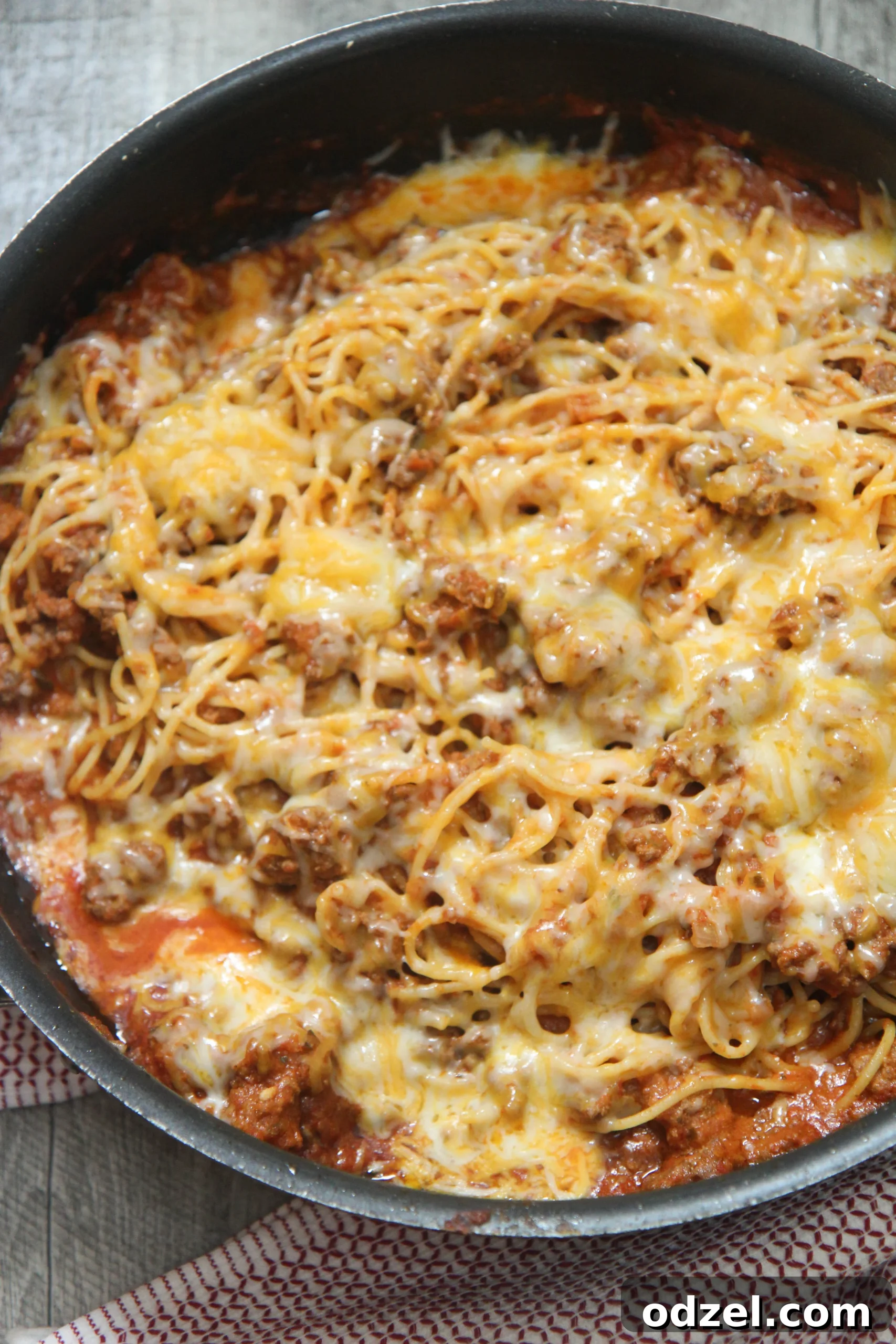 This easy taco spaghetti is perfect for a cold night or a family dinner. A bowl of cheesy taco spaghetti with fresh lime.