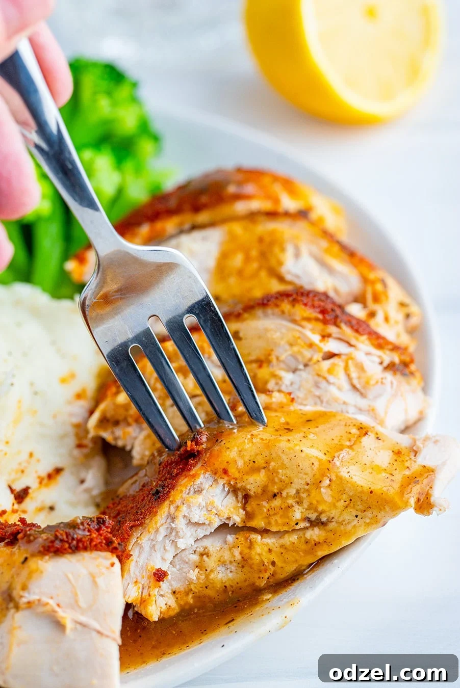 Fall-Off-The-Bone Slow Cooker Whole Chicken 4 sliced chicken breast with a fork and gravy.
