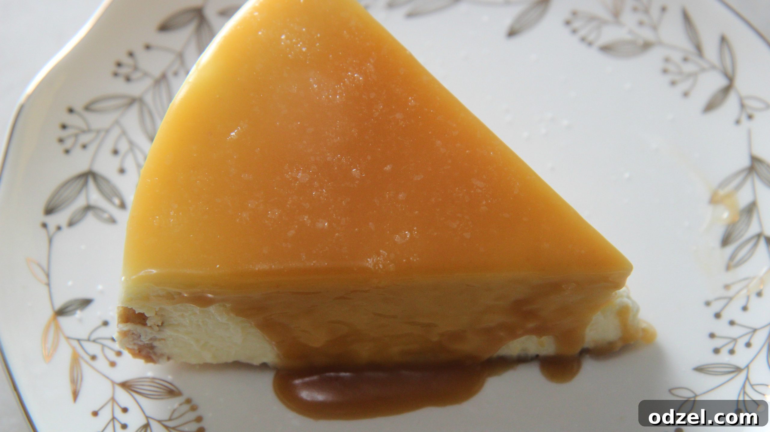 Decadent Sea Salt Caramel Cheesecake 6 A perfectly portioned slice of salted caramel cheesecake on a white plate, ready to be enjoyed.
