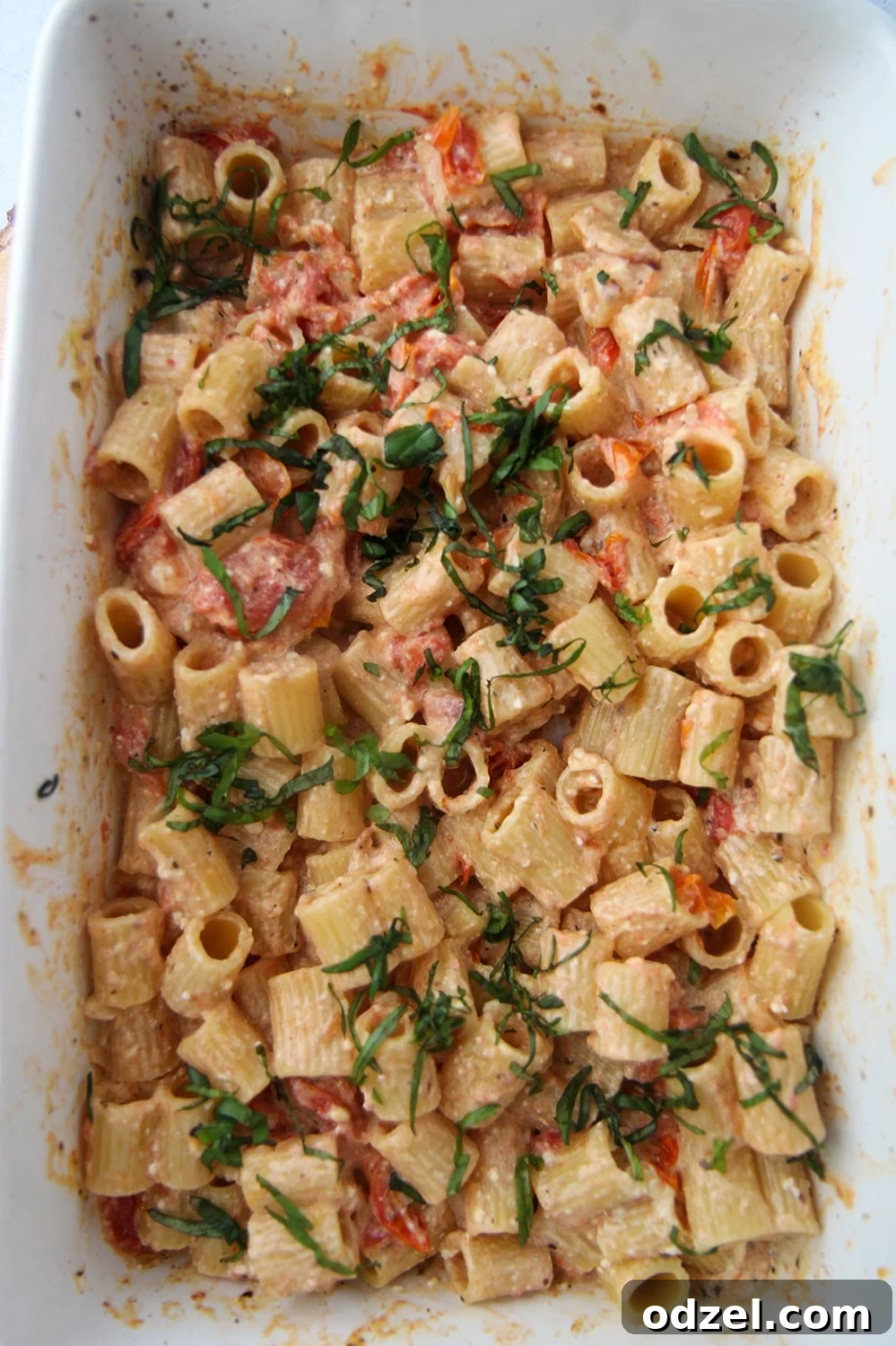 Baked feta pasta in a 9x13 baking dish, freshly mixed and ready to serve