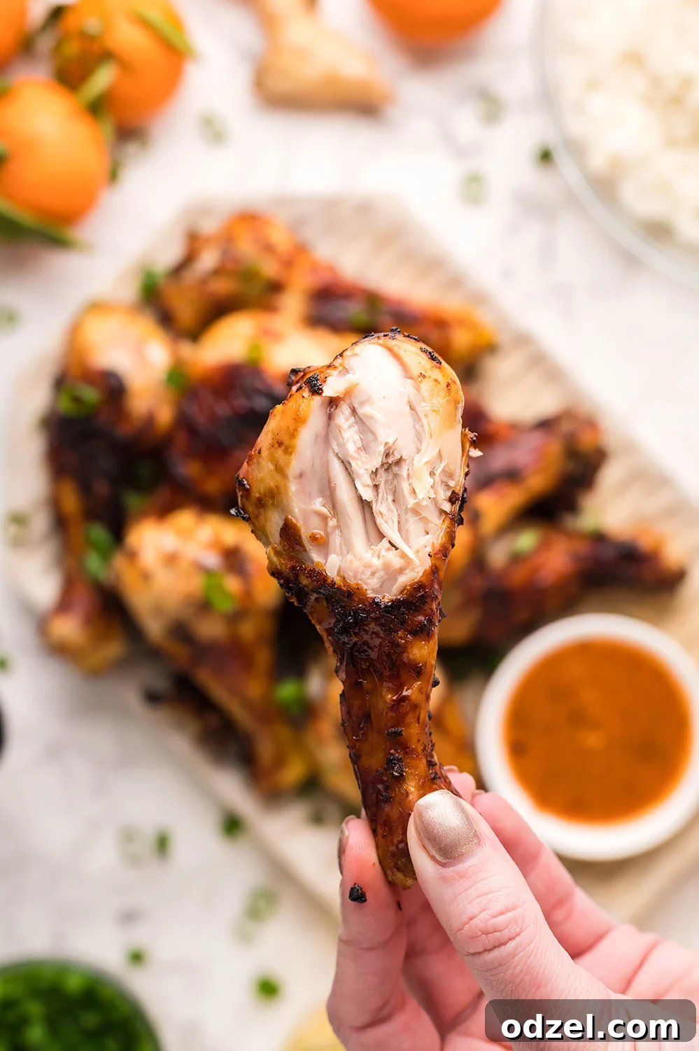 Juicy Crispy Air Fryer Drumsticks 4 A hand holding a perfectly cooked, bitten air fryer chicken drumstick, showing its juicy interior and crispy skin.