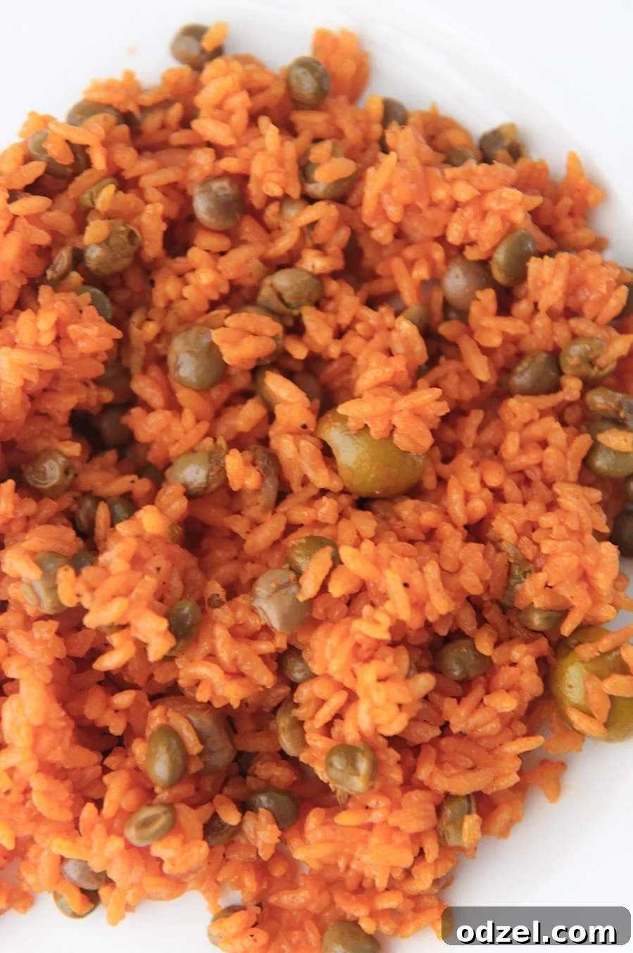 Arroz con Gandules Flavorful Rice and Pigeon Peas 4 yellow rice with pigeon peas on a white plate up close.