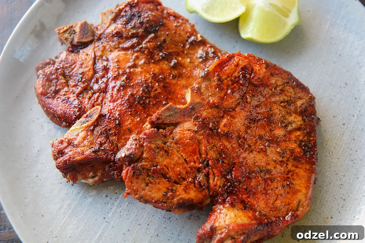 Crispy Golden Pork Chops 3 A close-up view of two perfectly fried pork chops, showcasing their golden-brown, crispy texture and savory seasoning.