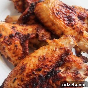 4 air-fried turkey wings on a white plate, served as a main dish.