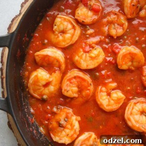 Cuban shrimp creole (enchilado de camarones) with red sauce in a black skillet up close.