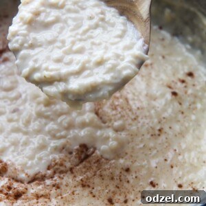 arroz con leche (rice pudding) in a large pot with a wooden spoon.