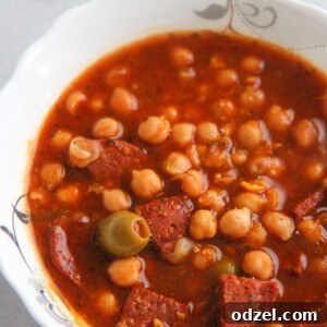 Garbanzos guisados in a white bowl up close.