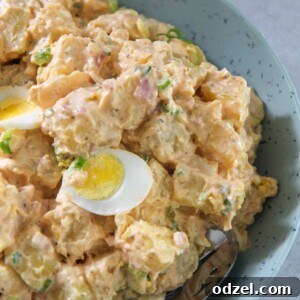 Southern Soul Potato Salad 2 Southern potato salad in a blue plate with a spoon.