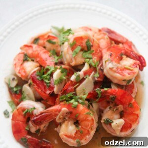 Camarones al Ajillo on a white plate with cilantro on top.