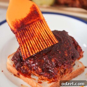 Nashville hot chicken on a slice of white bread and an orange brush.