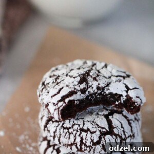 Three chocolate crinkle cookies on a small plate.