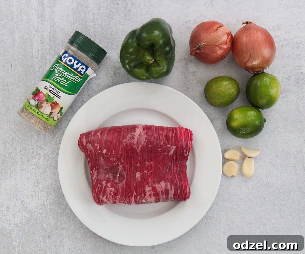Golden Crispy Shredded Beef 3 A selection of fresh ingredients for Vaca Frita, including flank steak, limes, garlic, and spices.