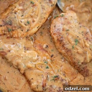 smothered chicken breasts in a skillet.