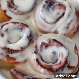 air fryer cinnamon rolls with cream cheese icing on top.