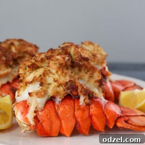 Decadent Air Fryer Stuffed Lobster Tails 2 air fryer stuffed lobster tails on a plate with lemon wedges.