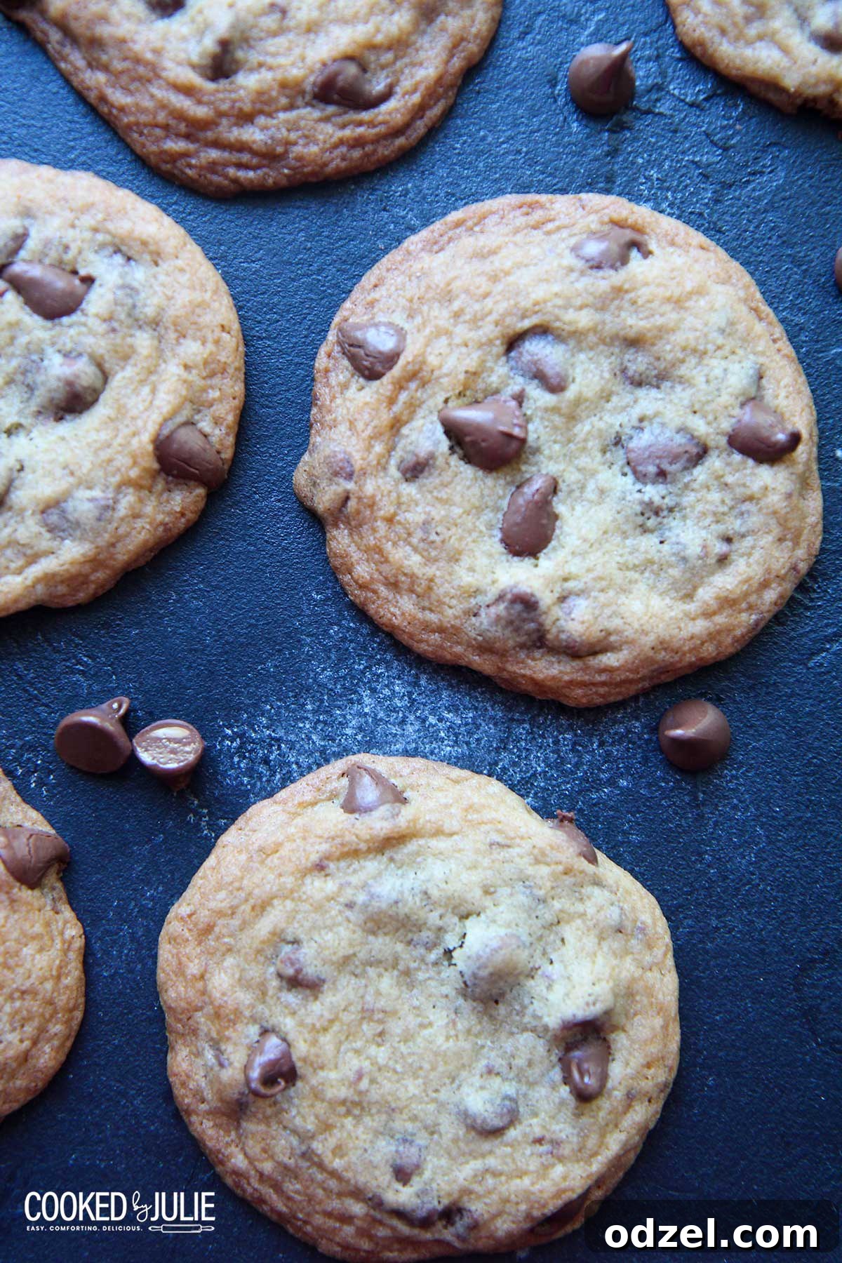 Ultimate Chocolate Chip Indulgence 7 A tempting batch of warm chocolate chip cookies displayed on a rustic blue board, showcasing their golden hue and molten chocolate pockets, ready to be enjoyed.