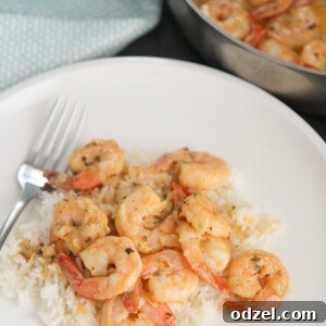 New Orleans style shrimp served with fluffy white rice, garnished with fresh herbs.