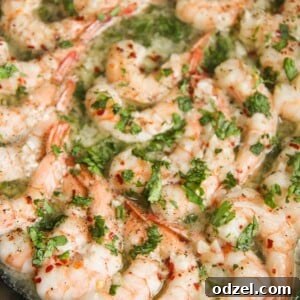 baked shrimp with parsley in a cast iron skillet up close.