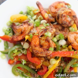 jerk shrimp with peppers and onions on a white plate.