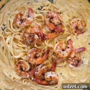 pumpkin fettuccine alfredo with shrimp in a cast iron skillet.