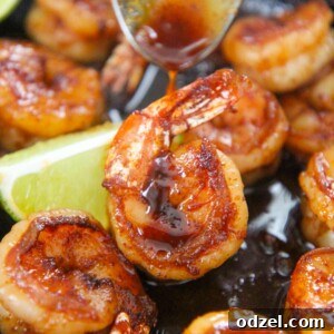 honey chili lime shrimp up close with a spoon drizzling sauce on top.