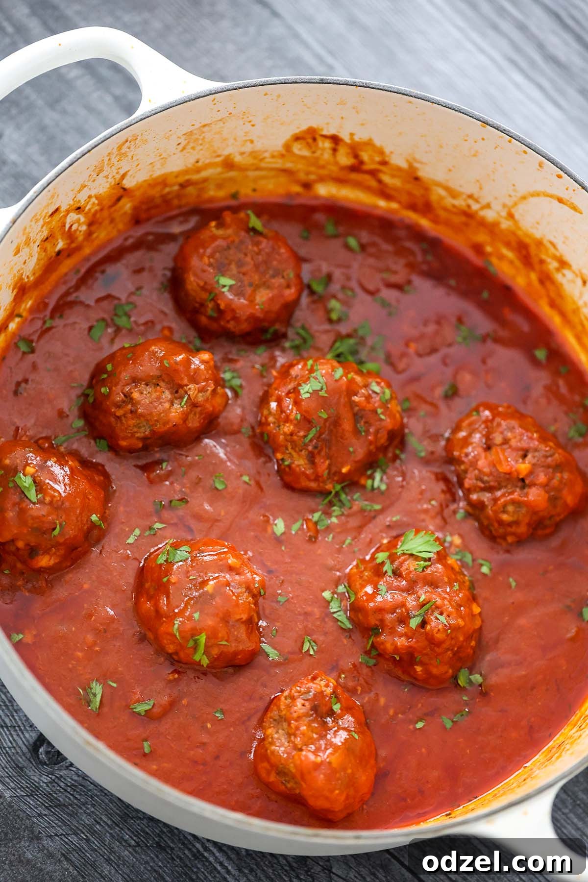 Authentic Cuban Meatballs 4 Albondigas with rich tomato sauce simmering in a Dutch oven, ready to serve.