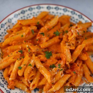 Penne Alla Vodka served on a plate, garnished with fresh herbs.