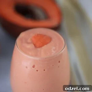 batido de mamey in a glass with a piece of fruit on top.